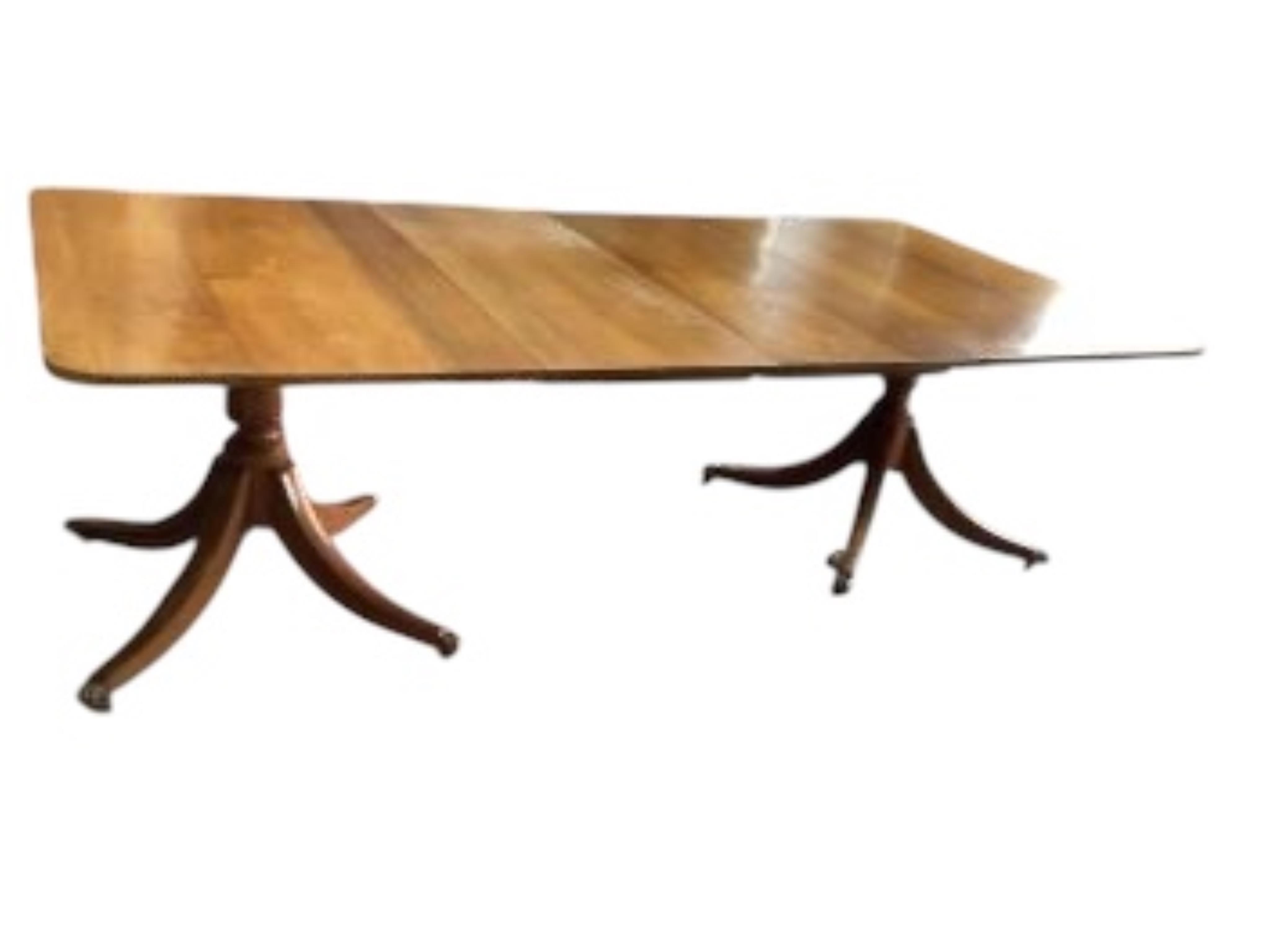 A Georgian style mahogany twin pillar extending dining table with two leaves, width 234cm extended, depth 117cm, height 74cm. Condition - fair